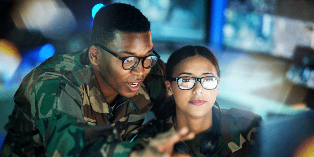 A man and woman in camouflage doing night surveillance.